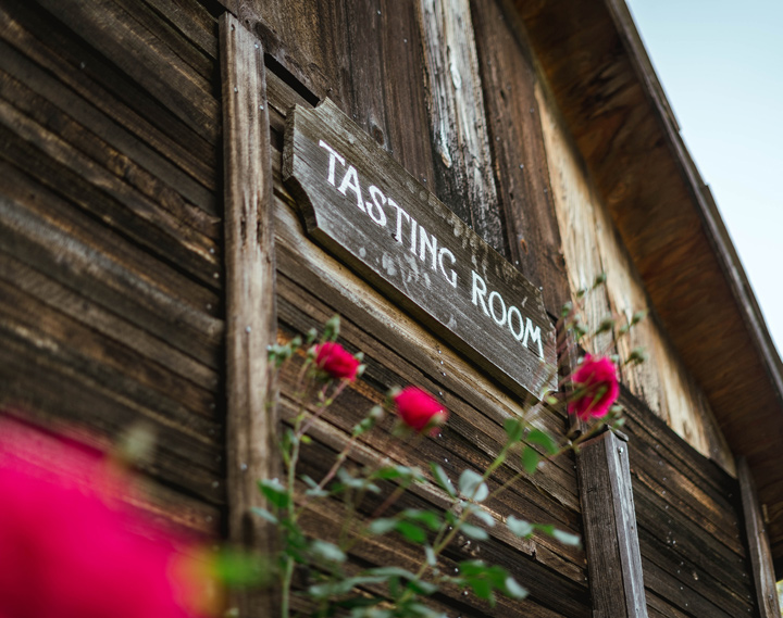 Wooden welcome sign on the wood clad exterior of the tasting room